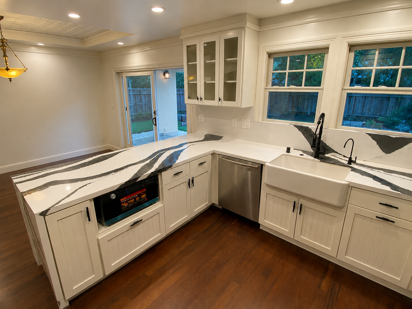 Finished white shaker kitchen with black-and-white quartz counters and farmhouse sink